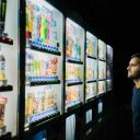 Man deciding what to buy from a number of food vending machine